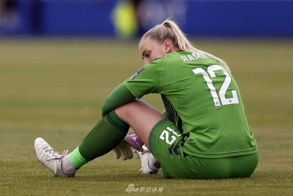 阿森纳球员进球后张开双臂，面向随队远征的客队看台激情滑跪庆祝，身后是呆立的埃弗顿后卫。