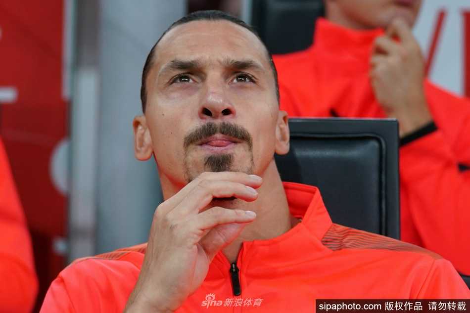 身穿红黑战袍的伊布在圣西罗的灯光下目光如炬，他高举双臂向看台示意，仿佛君临天下的王者，身后的看台上是无数为他欢呼的球迷组成的红黑海洋