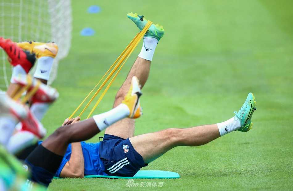 训练接近尾声，全体队员在场地中央围成一个大圈，肩并着肩，高喊着鼓舞士气的口号，夕阳的余晖洒在他们身上，为这充满力量的一幕镀上了金色的光芒。