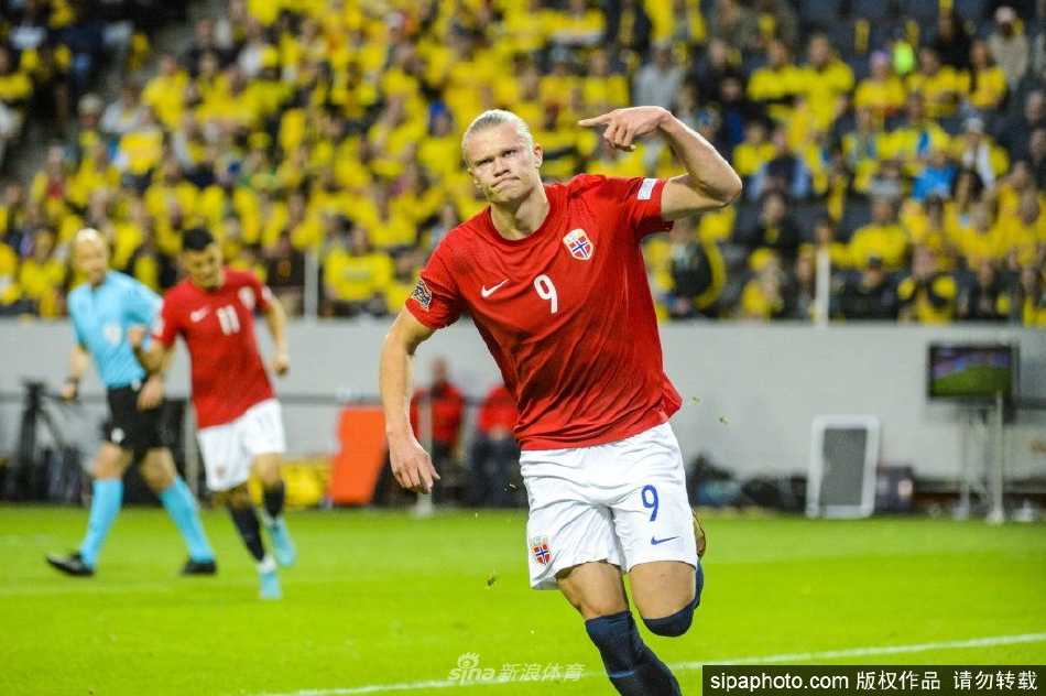 哈兰德与国家队队友激情相拥庆祝进球，画面充满了团队的凝聚力与胜利的喜悦