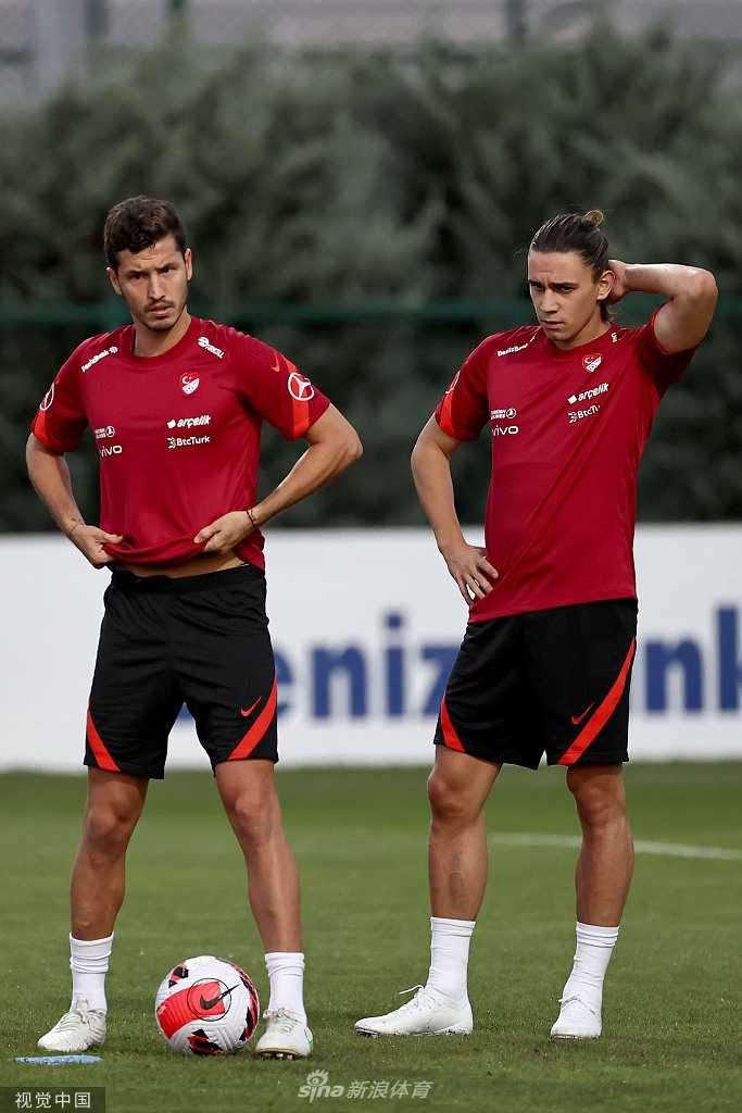 特写镜头下，伊尔马兹笑着伸出三根手指，他的对手则紧紧握拳。两人眼神交汇，充满了朋友间的嬉戏感。背景虚化的训练场和队友，更衬托出这一刻的主角是他们轻松愉悦的心情。