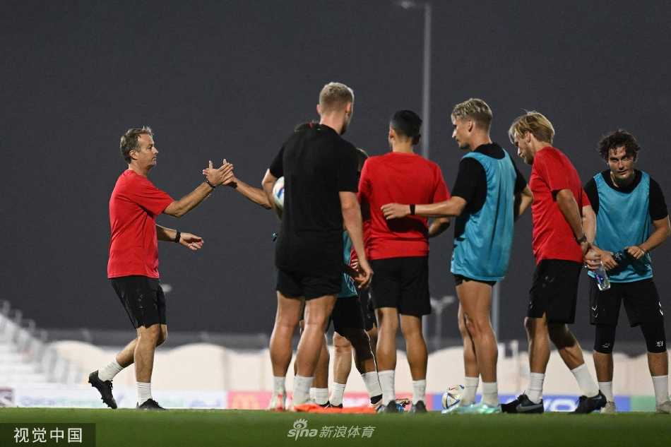 两名丹麦队球员在训练中友好击掌，击掌瞬间既是鼓励也是竞争，体现了团队内部良性的竞争与合作关系。