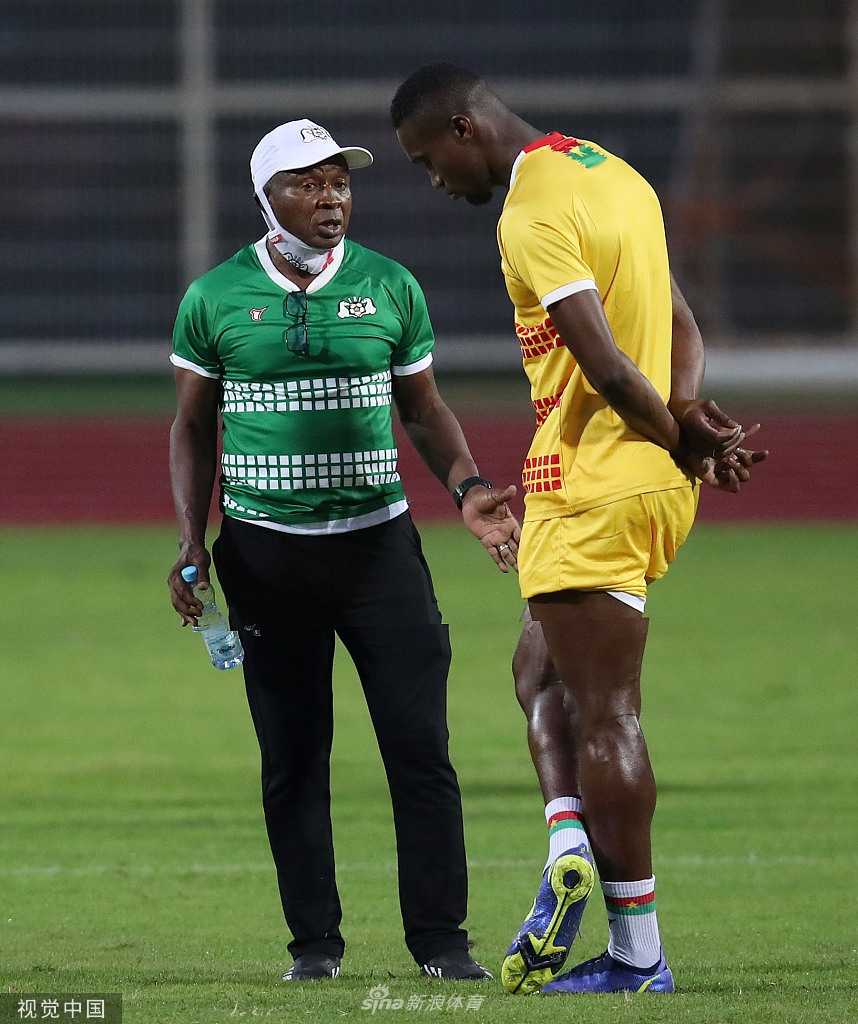 训练间隙，布基纳法索队的主教练正召集球员围拢，手持战术板进行细致的讲解，球员们聚精会神地聆听。