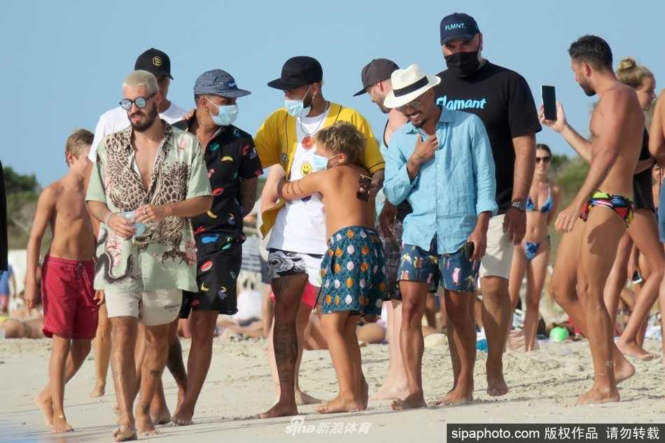 游艇的甲板上铺满了诱人的食物，内马尔赤裸上身坐在中间，脸上带着闲适的微笑，与朋友们分享着惬意的度假时光。