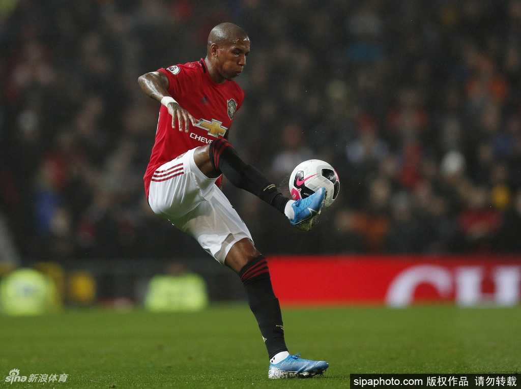 在室内摄影棚中，阿什利-扬穿着国际米兰的经典主场球衣，双手自然下垂，神情专注而威严，完美展现了作为新援的飒爽英姿。