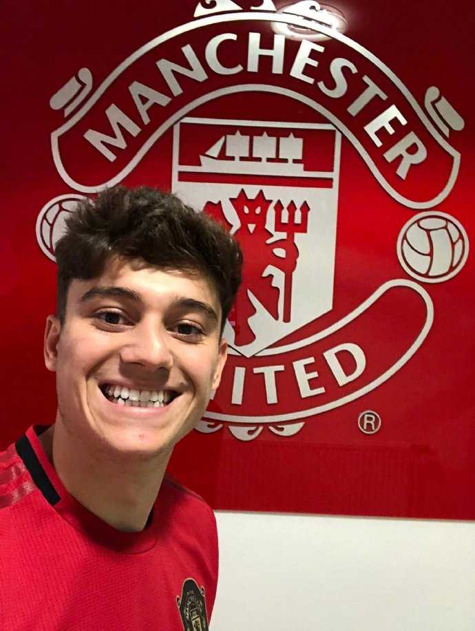 镜头定格在丹尼尔·詹姆斯的侧脸，他神情坚定，目光凝视远方，红魔的队徽在他胸前熠熠生辉，仿佛在诉说着一位少年背负着荣耀与梦想的决心。