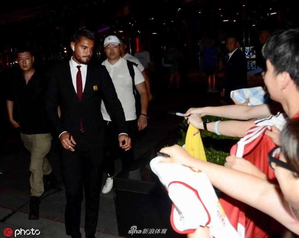 深夜的上海虹桥机场到达口，身着曼联各色球衣的球迷高举围巾和海报，目光聚焦通道口，等待偶像出现