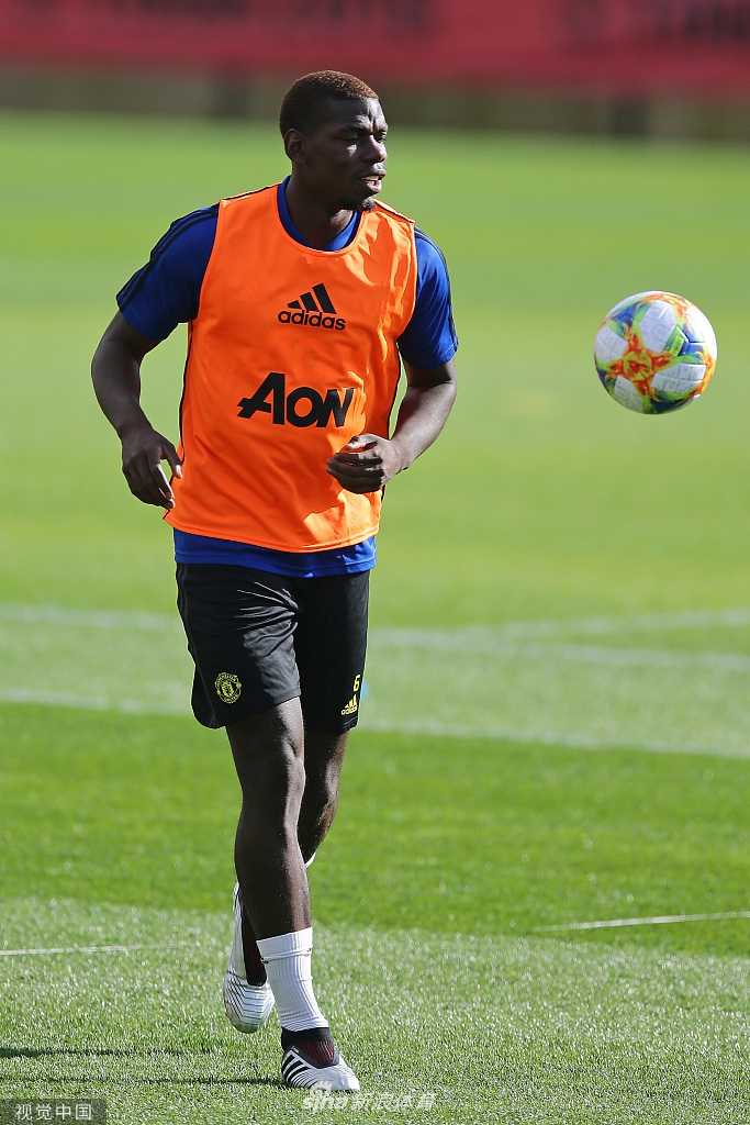 博格巴在训练中回头观望，眼神中带着一丝警觉与疏离，紧抿的双唇和紧锁的眉头似乎诉说着与周围喧嚣格格不入的内心独白。