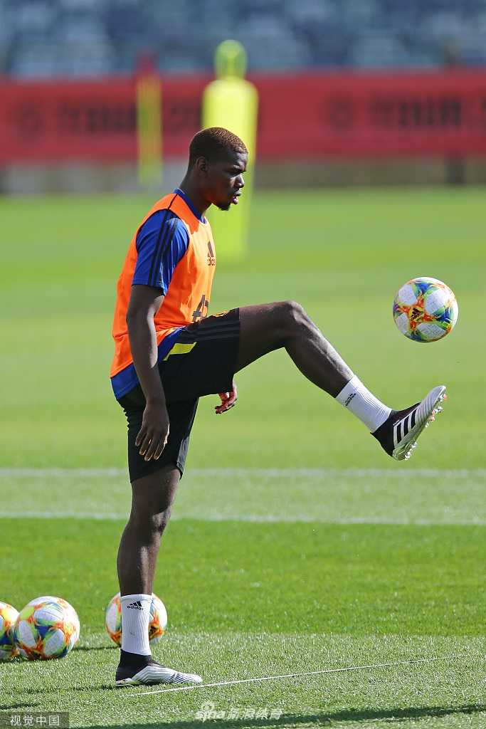 低角度拍摄的博格巴正在进行拉伸训练，面部肌肉紧绷，眉头拧成一股绳，背景是模糊的澳洲天空，突显出他此刻内心的不平静与专注。