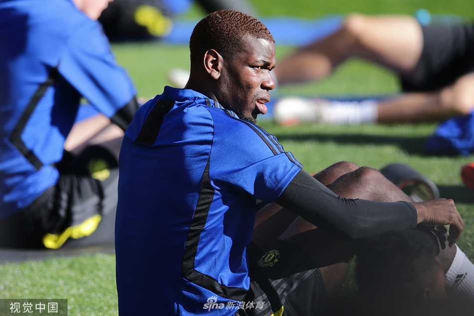 训练间隙，博格巴独自叉腰站立，汗水浸湿了球衣，神情若有所思，远处的队友正在热身，整个画面弥漫着一种备战期的紧张与孤独感。