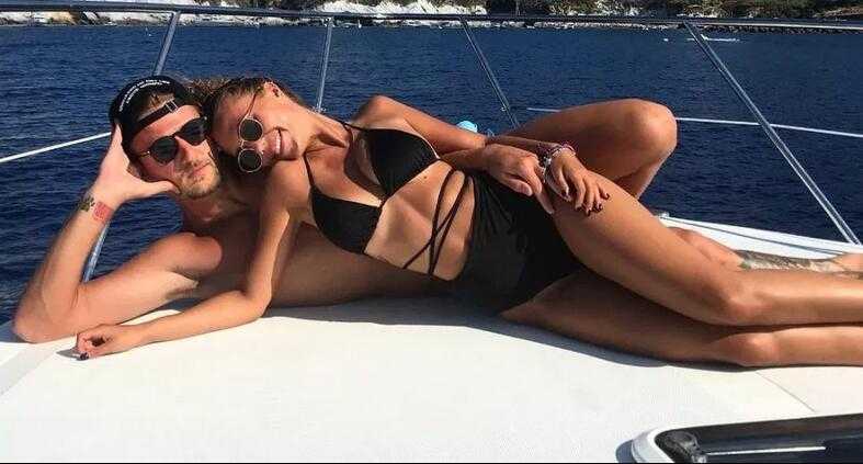 两人在海边度假时留下的背影，米林科维奇轻拥女友，娜塔莉亚身着波西米亚风长裙，画面唯美浪漫，羡煞旁人