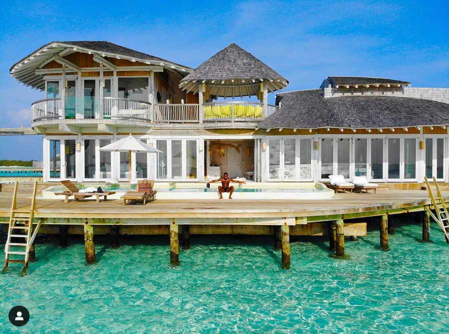 暮色降临，水上屋亮起暖黄色的灯光，照亮了下方的海面。弗雷德从巨大的水滑梯顶端一冲而下，像个孩子般开心地溅起大片水花