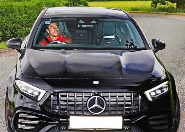 曼联球星博格巴驾驶着一辆哑光灰色的劳斯莱斯，眼神坚定地望向远方，这辆顶级豪车在阳光下反射出沉稳而奢华的光泽，仿佛在宣告他的王者归来。