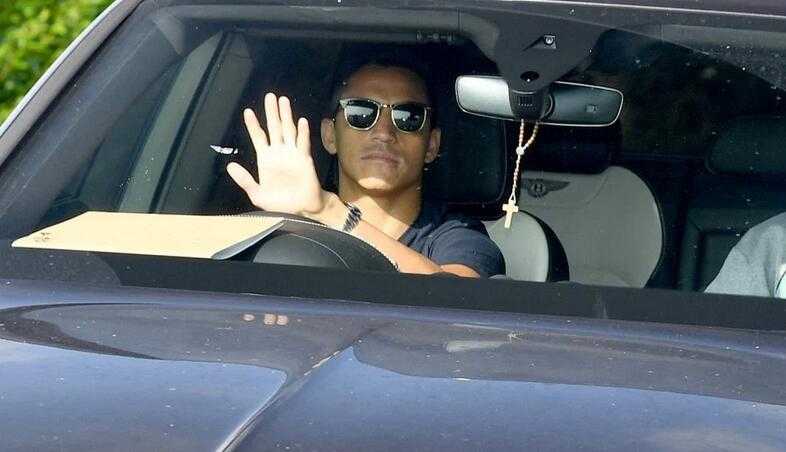 智利杀手桑切斯在训练场上眉头轻蹙，眼神深邃地望向远方，仿佛在思考与曼联之间那难以言说的未来迷局