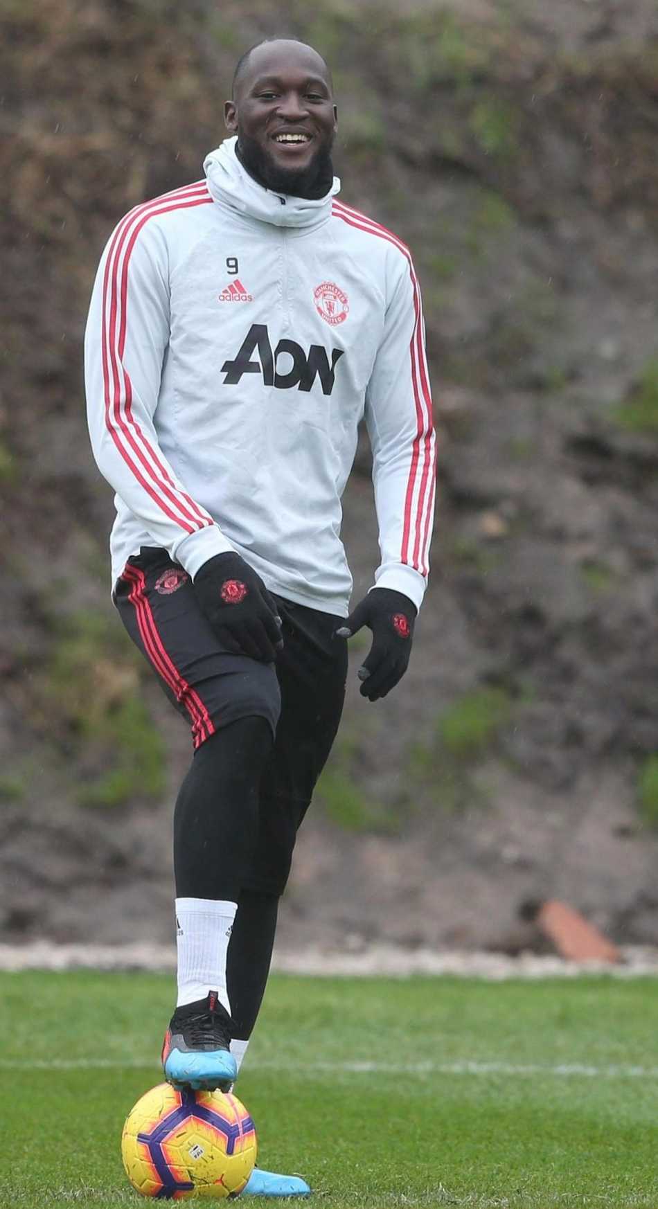 远景镜头下，整个曼联训练场沐浴在阳光下，球员们三五成群，有的在拉伸，有的在闲聊，每个人的脸上都带着笑意，整个训练基地都洋溢着轻松欢快的气息。