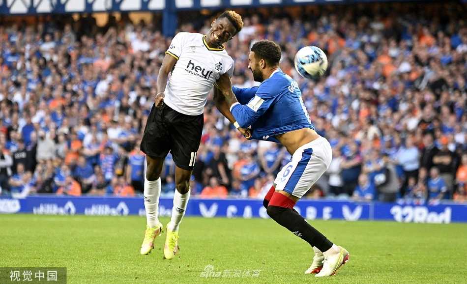 伊布罗克斯球场看台被激情澎湃的流浪者队球迷淹没，蓝白色旗帜与围巾汇成一片汹涌海洋