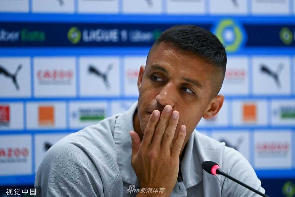 桑切斯面带灿烂笑容，正在发布会文件上签名，标志着他与马赛俱乐部合作的正式开始。