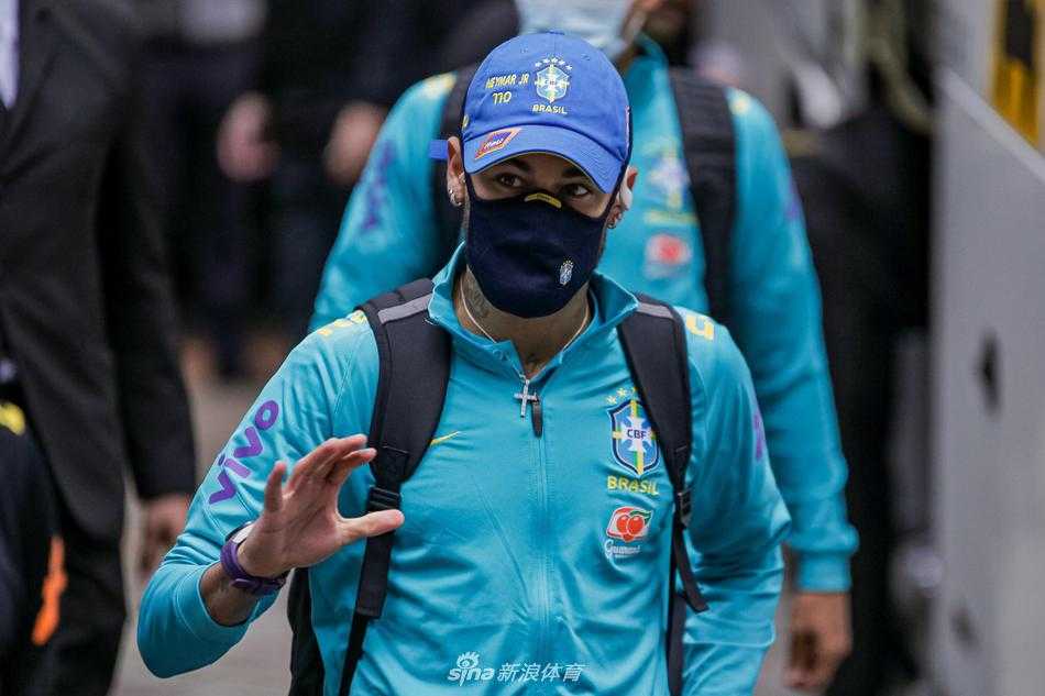 在阿雷格里港的清晨阳光下，巴西国家队球员们身穿整齐的队服，提着行李车穿过停机坪，走在最前方的球员眼神坚毅，仿佛已瞄准了巴拉圭的球门。