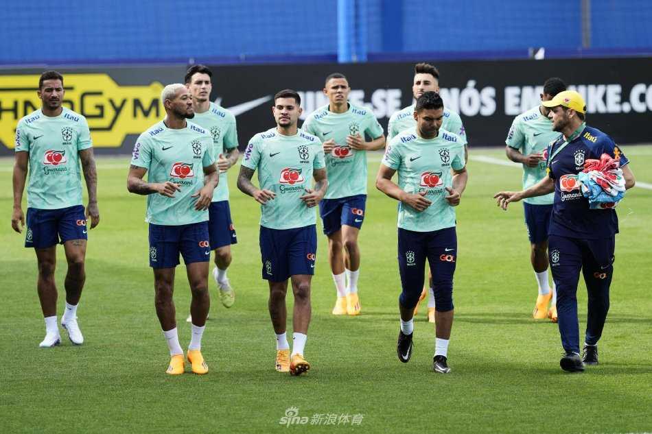 巴西队核心球员围成一圈进行战术部署，主教练站在中央，手指远方，讲解攻防策略，队员们神情专注，气氛严肃而充满凝聚力。