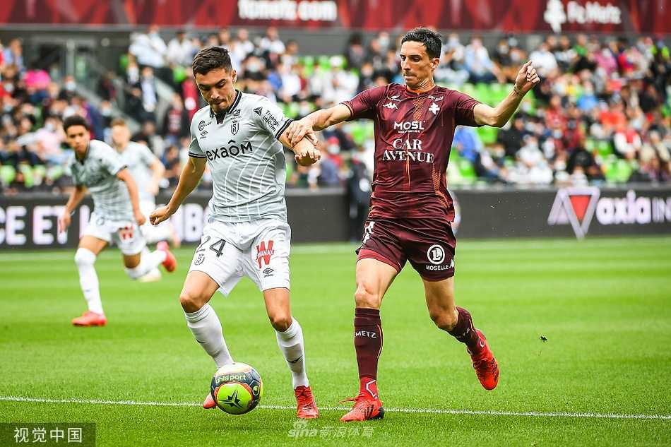 圣西姆福里安球场的夜雨中，梅斯球迷在看台上挥舞着酒红色围巾，目光紧紧追随场内球员的争抢，助威声穿透了湿冷的空气