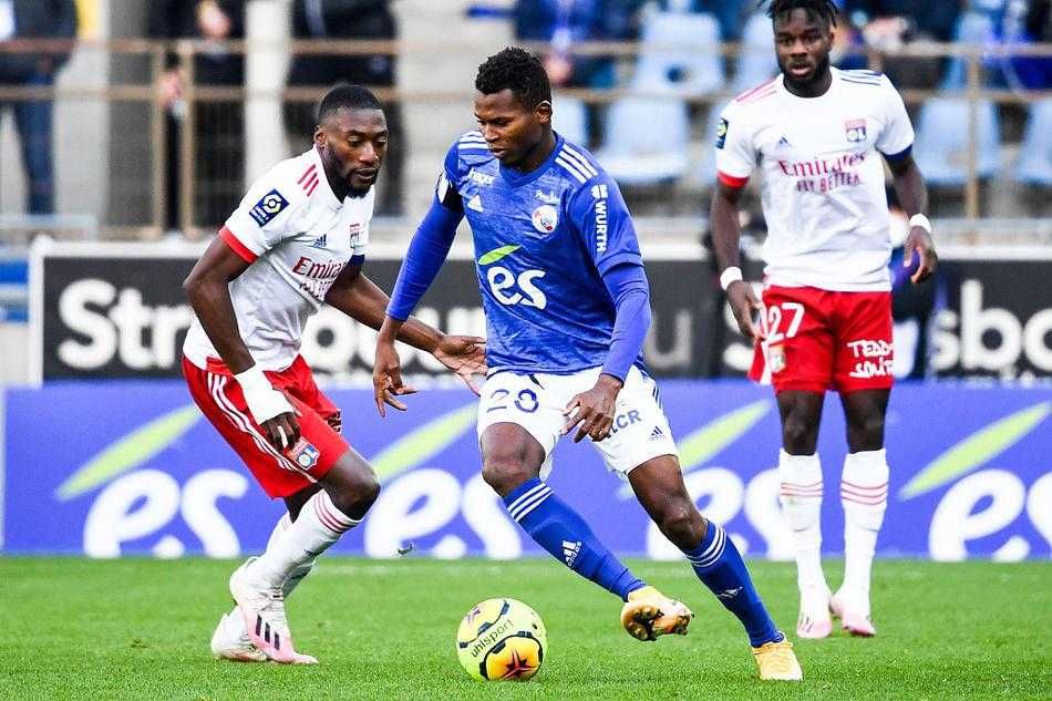 梅斯瑙球场的蓝白拥趸们在寒风中挥舞旗帜，他们凝视着球场，眼神中充满了对主队绝地反击的殷切期盼，背景是阿尔萨斯深秋湛蓝的天空。