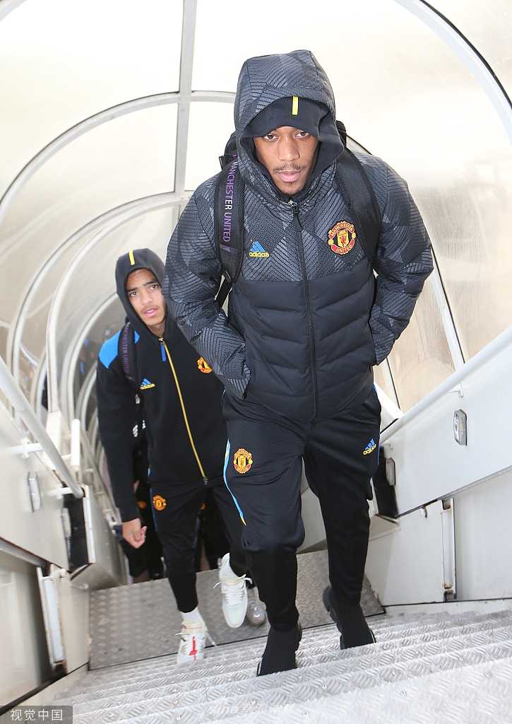 拜利与亚特兰大前锋萨帕塔在争顶头球时肌肉紧绷，两人在空中对抗，展现了比赛激烈的身体对抗强度