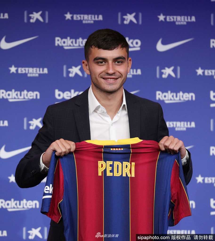 佩德里与巴托梅乌并肩而坐，他身着白色衬衫，青涩的脸庞上挂着对未来憧憬的微笑，面前的桌签上清晰地印着他的名字，这一刻，梦想照进现实。