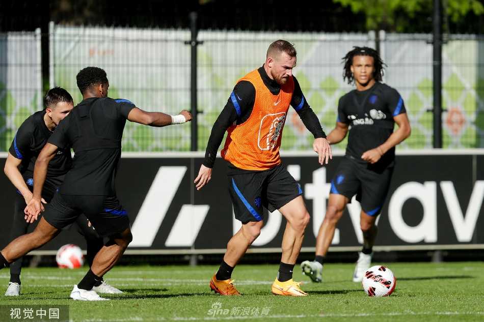 训练结束后，球员维纳尔杜姆与队友边走边交流，夕阳将他们的身影拉长在草皮上。