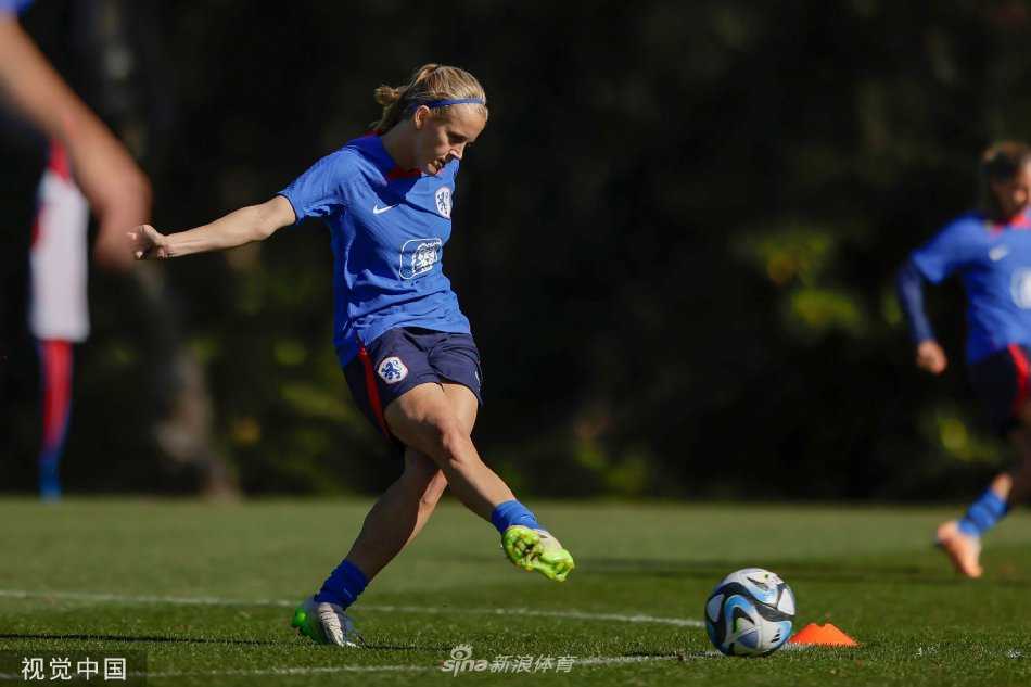 荷兰女足前锋在训练中灵动转身，橙色战袍在绿色草坪上划出一道疾风般的轨迹，眼神锐利如鹰隼，紧盯着球门方向。