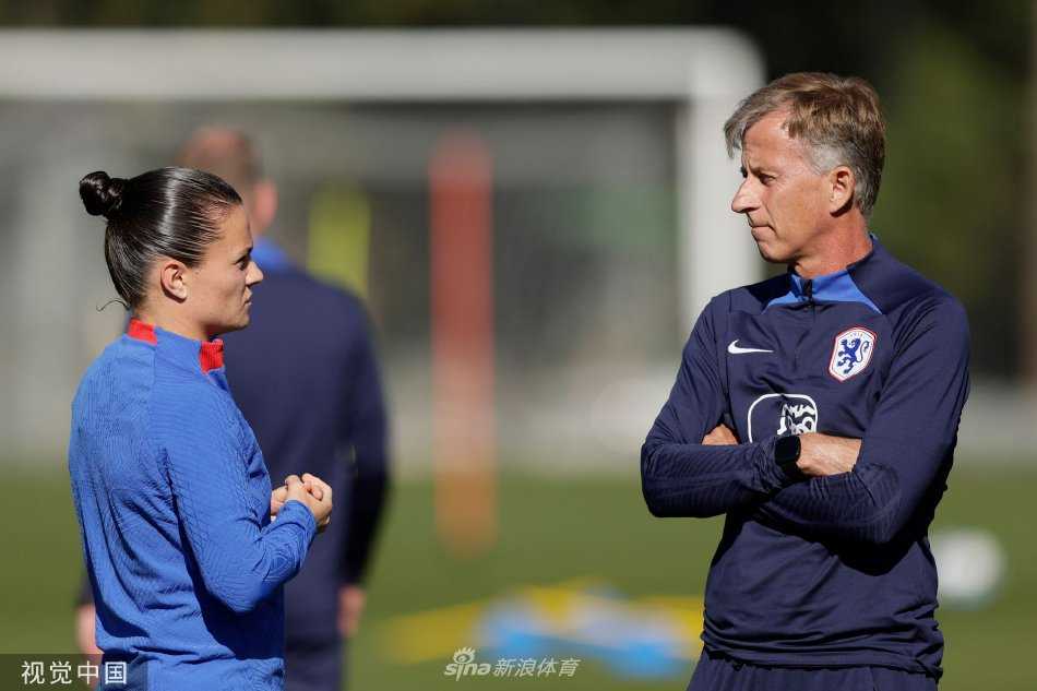 全队围成一圈聆听主教练的战术布置，一张张认真的面孔凝聚着共同的目标，橙色的队伍在绿茵场上形成一个团结的圆心。