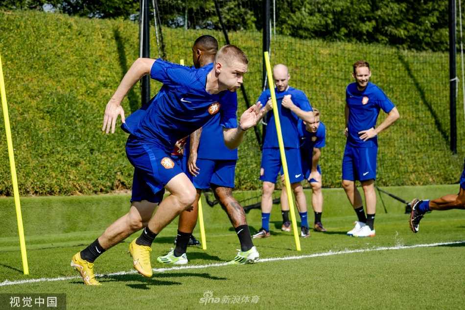 球员们围成一圈进行拉伸放松，在紧张的训练间隙相互交流，体现了团队内部的融洽与凝聚力。