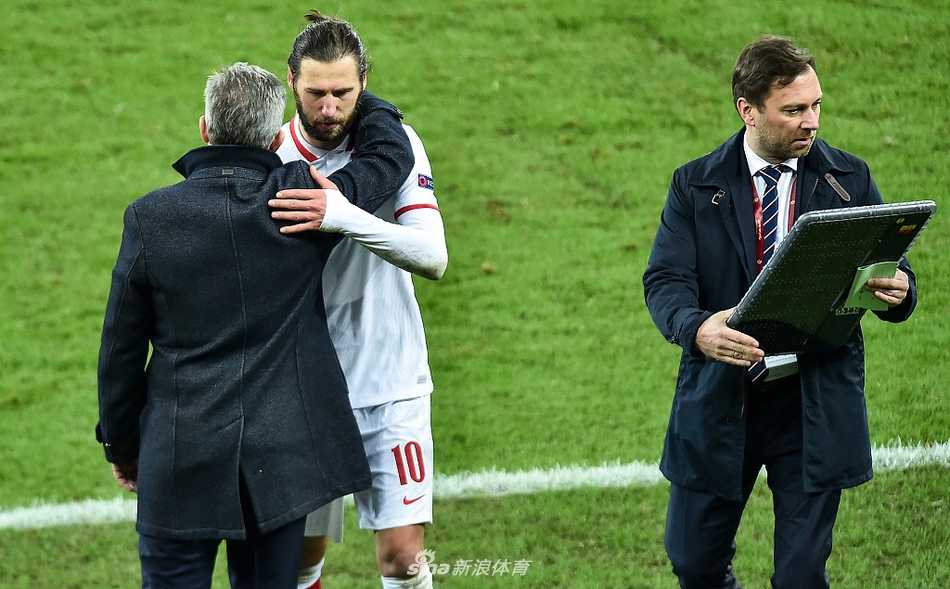 波兰前锋莱万多夫斯基在比赛中背身护球，他身前的荷兰后卫布林德正全神贯注地进行贴身防守，空气中弥漫着紧张的气息