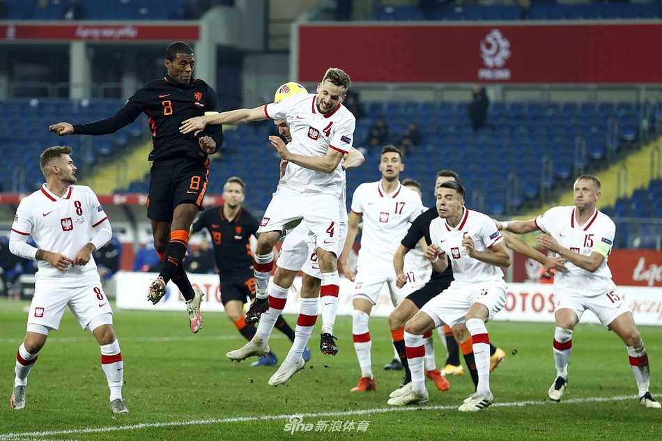 波兰门将法比安斯基在禁区线上奋勇扑救，指尖几乎触碰到皮球，身后的草皮被铲起一片水花