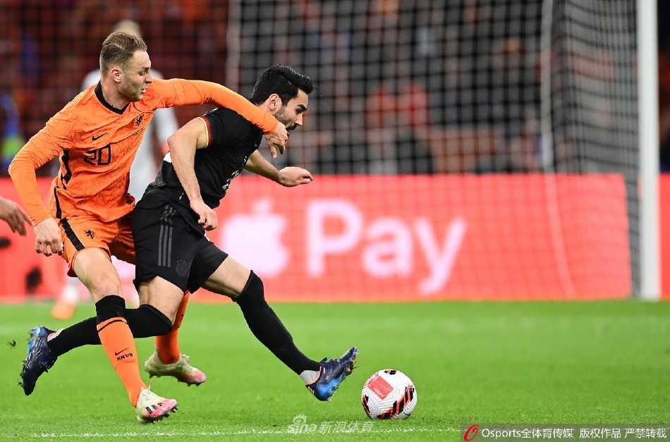 德国队球员在边路精巧二过一配合，荷兰防守球员奋力回追拦截