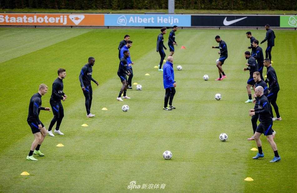 多名荷兰队球员在训练场上围成一圈，进行抢圈热身，气氛轻松而专注，核心德容也在其中开怀大笑