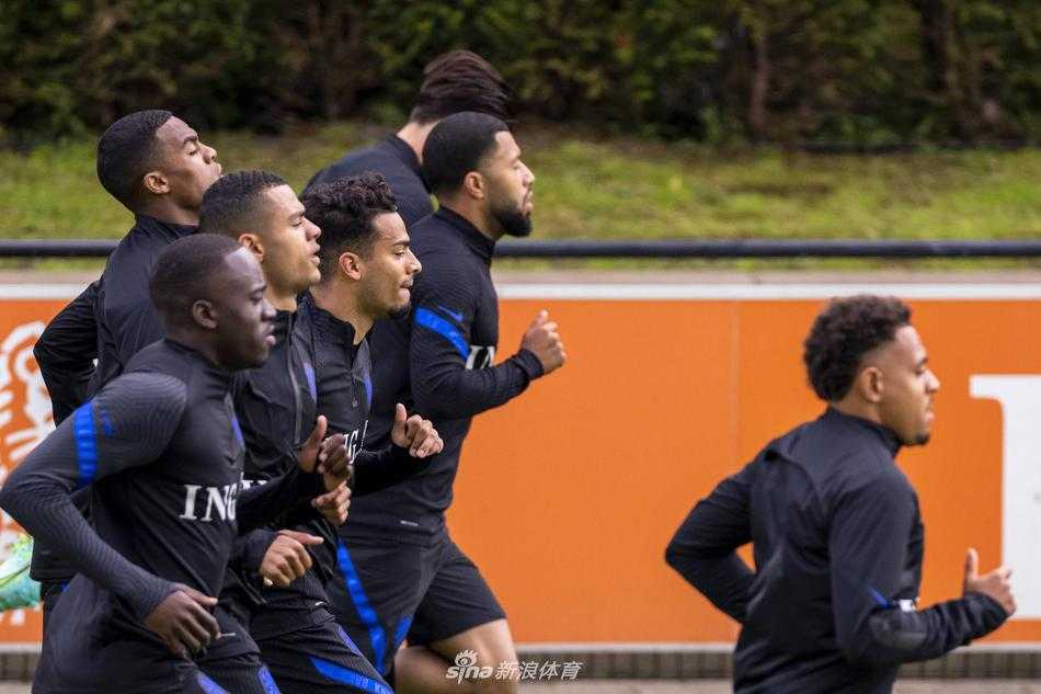 孟菲斯·德佩在训练中带球疾进，眼神犀利，他身旁的防守球员奋力追赶，展现了锋线尖刀的犀利突破