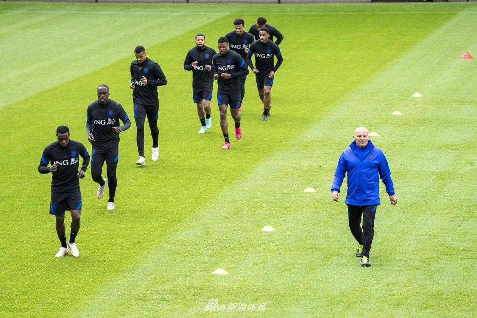 维纳尔杜姆作为队长带领全队进行慢跑放松，夕阳的余晖洒在橙色的训练服上，画面充满凝聚力与希望