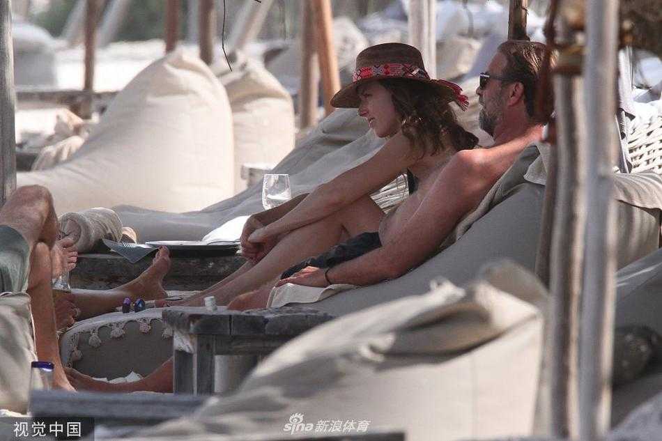 夫妻二人并肩坐在海边的礁石上，乌拉温柔地依偎在克洛普身侧，两人共同远眺着波光粼粼的加勒比海，享受着夺冠后难得的宁静时光。