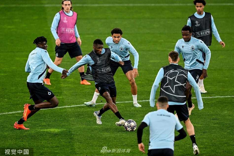 里斯本夕阳下，布鲁日球员专注进行传球训练，皮球在绿茵上划出精准的轨迹