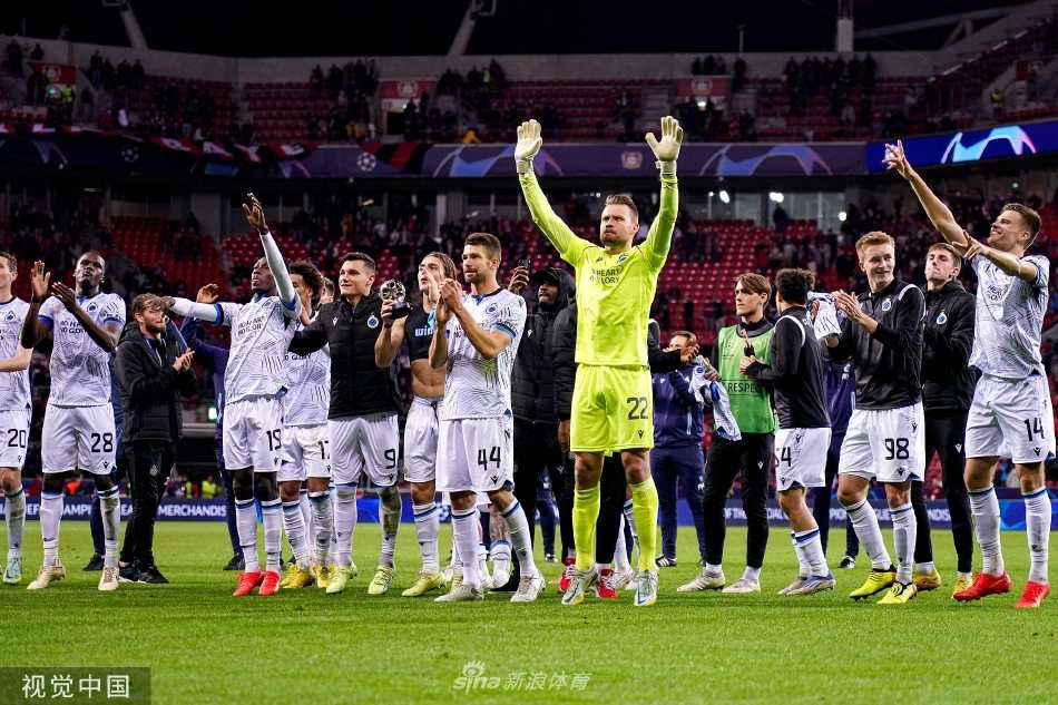 勒沃库森前锋在布鲁日两名后卫的贴身夹击下艰难护球，肌肉紧绷，展现欧冠级别的身体对抗强度