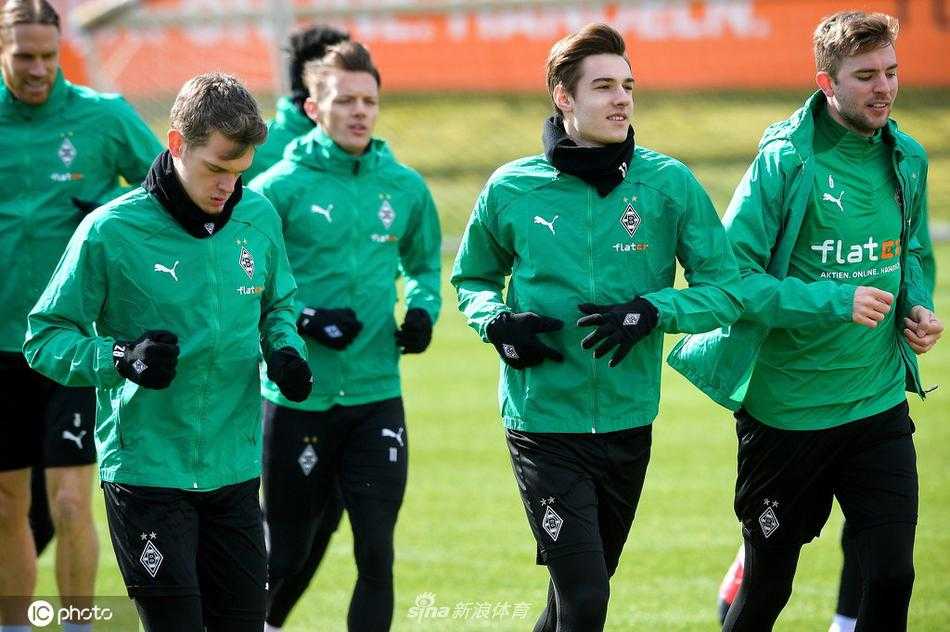 绿茵场上的专注瞬间，门兴球员在训练中神情严峻，阳光勾勒出他坚毅的轮廓，每一次触球都仿佛在与命运抗争。