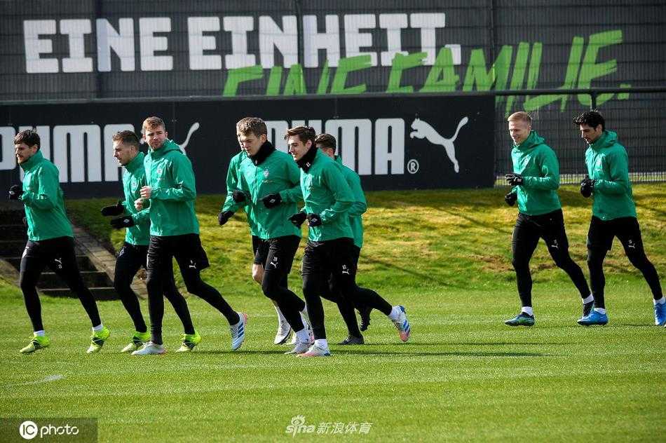 训练场边的足球静静等待，背景是球员们模糊的身影。这静谧的一刻，仿佛是暴风雨来临前最后的安宁，静待欧冠战鼓的再次擂响。