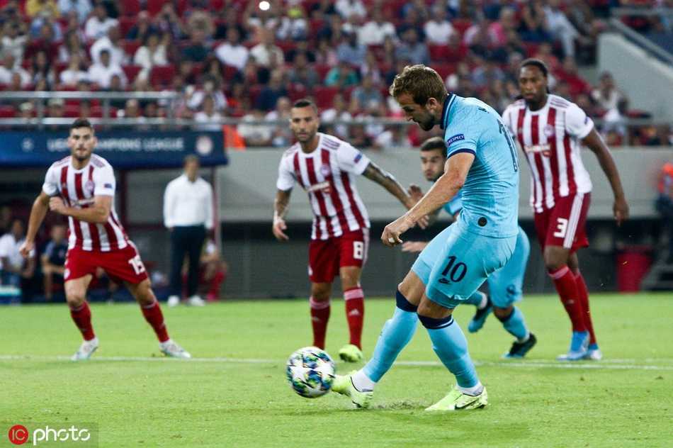 奥林匹亚科斯球员博登斯进球后跪地怒吼，庆祝他在欧冠赛场的处子球，身后是沸腾的希腊球迷看台