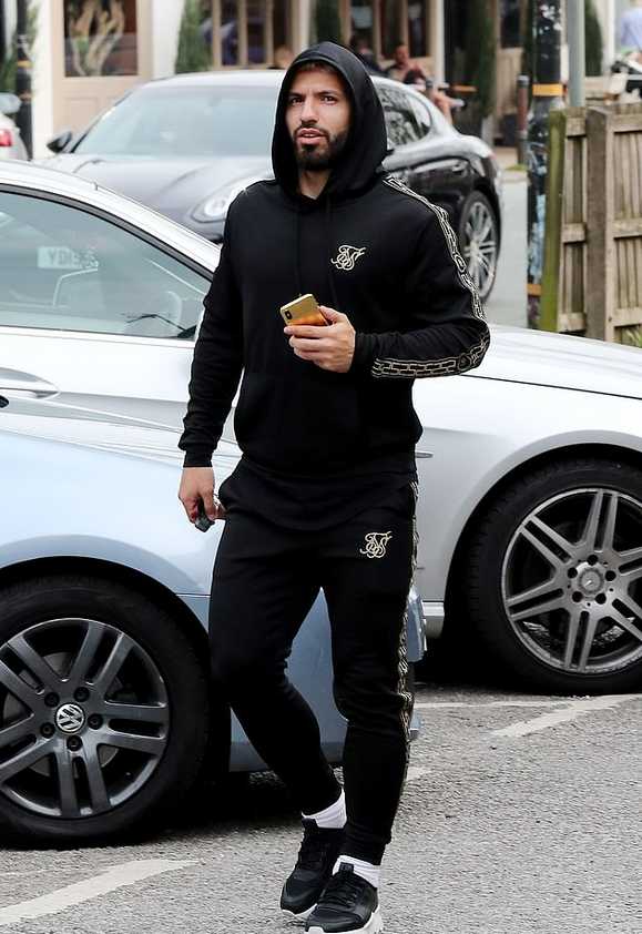 从侧面拍摄的阿圭罗，他穿着休闲连帽衫，正准备进入餐厅，神情放松，丝毫看不出几个小时前刚经历了一场心碎的比赛