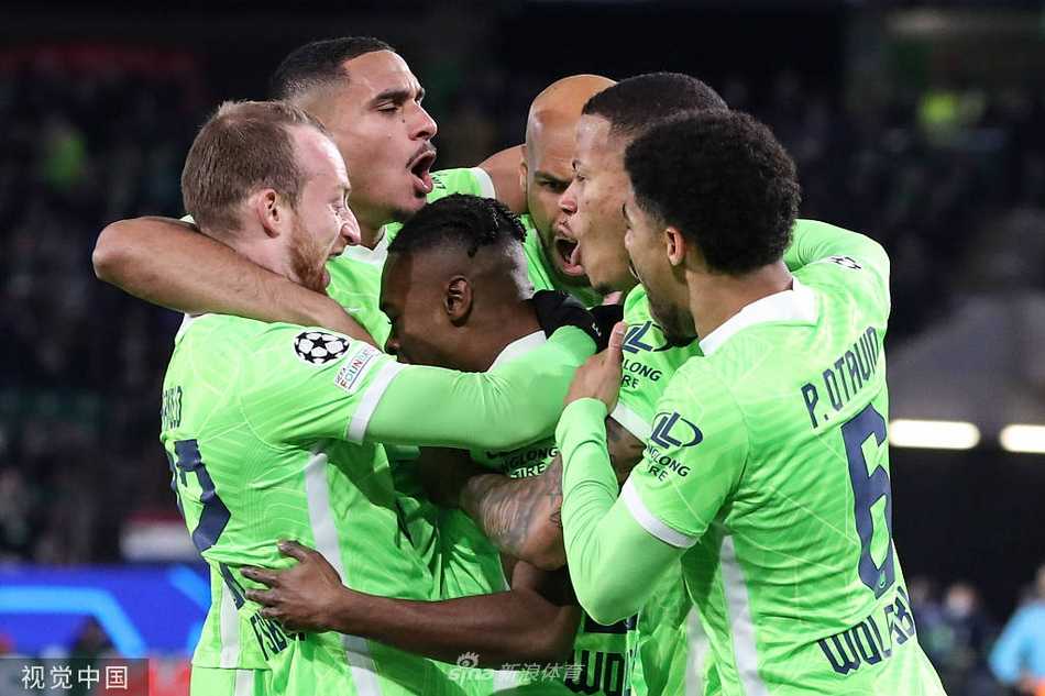 大众汽车竞技场的璀璨夜空下，沃尔夫斯堡的球员们激情相拥，为这场关键的欧冠胜利欢呼雀跃，绿色草皮映衬着他们沸腾的喜悦。