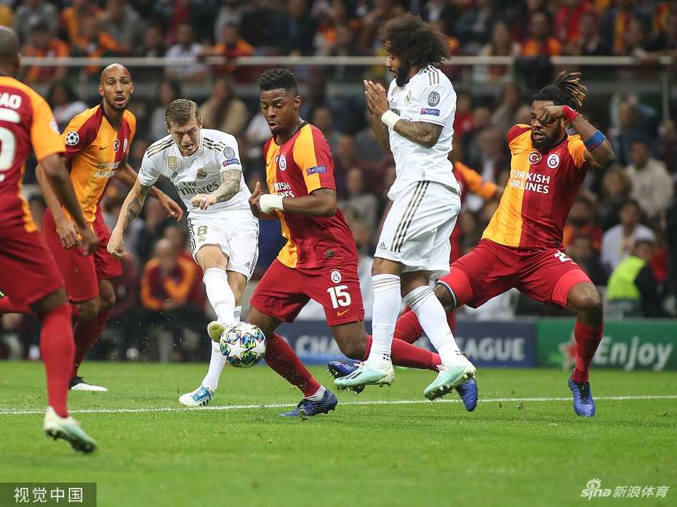 阿扎尔身着白色球衣，在两名黄色球衣防守球员的包夹下，依然用娴熟的假动作试图突破，脚下的皮球仿佛粘在脚上。