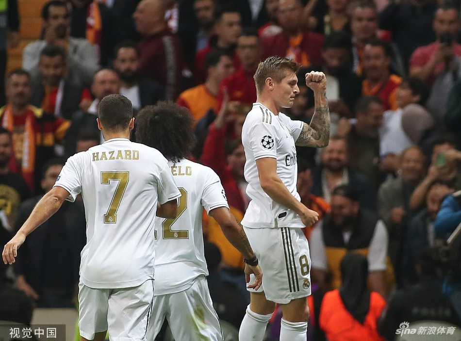 克罗斯进球后张开双臂奔跑欢呼，脸上洋溢着激动的笑容，身后的队友本泽马、阿扎尔等人纷纷冲向他，拥抱庆祝这粒宝贵的客场进球。