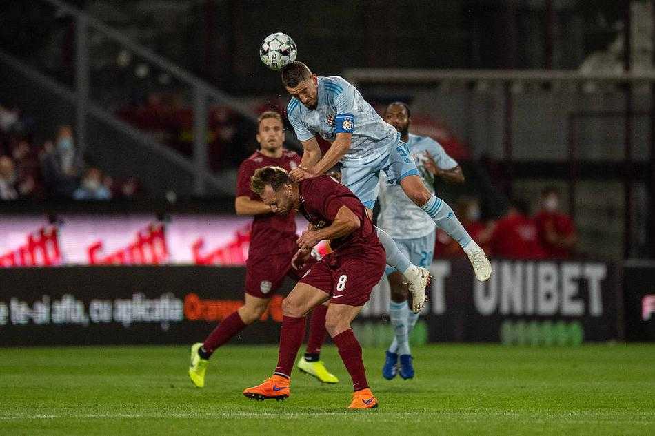 克卢日球员在空荡的看台前奋力拼抢，草皮上飞溅的汗水仿佛诉说着空场之下的孤寂与决绝