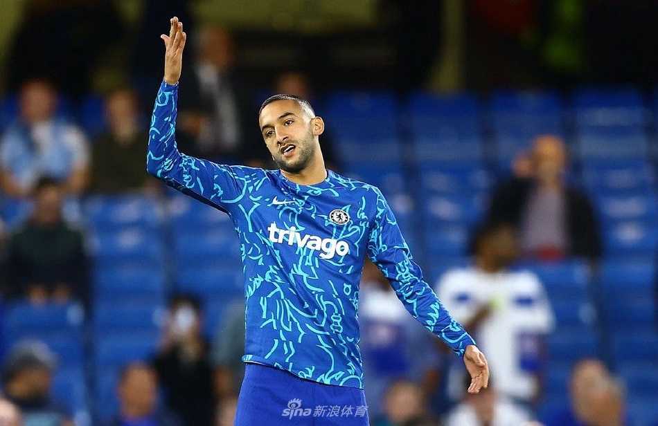 切尔西前锋斯特林进球后张开双臂奔跑庆祝，为球队打破僵局，背景是欢呼的蓝色看台。