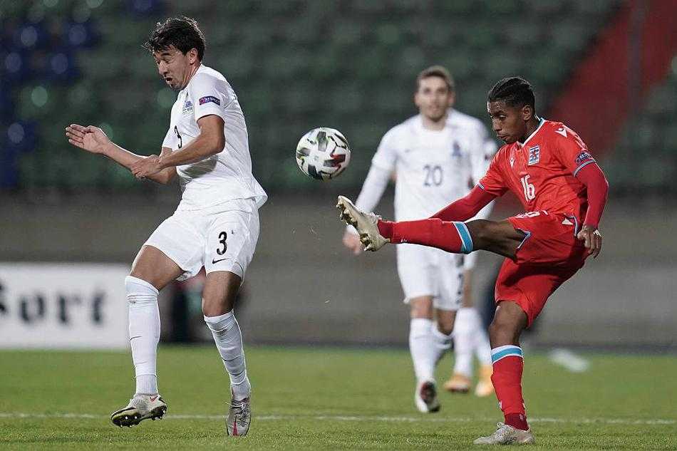 阿塞拜疆门将飞身单掌将球托出横梁的瞬间，身体在空中完全舒展，像一张拉满的弓，背景是卢森堡球员懊恼的身影。